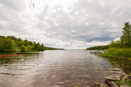 Gorgeous nature landscape view of lake surrounded with green forest trees. Sweden.の写真素材