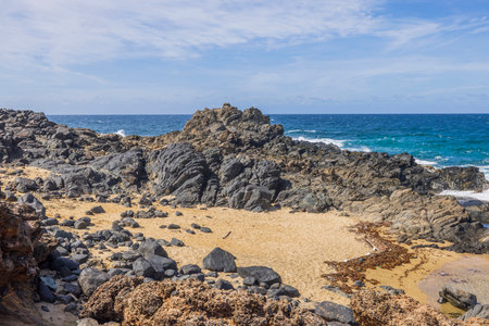 Beautiful rocky coastline and blue water surface of the Atlantic Ocean. Aruba.の写真素材