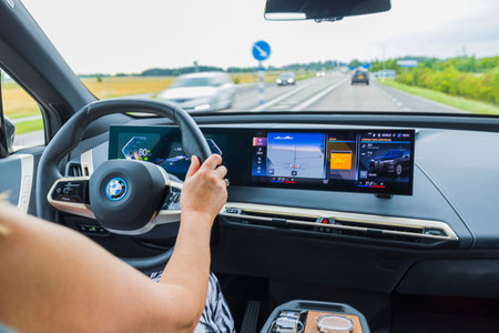 Beautiful expensive view of interior of BMW iX40 electric car driven by female driver on highway....