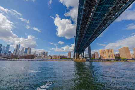 View of Brooklyn Bridge over Hudson River and skyscrapers of Manhattan against blue sky with white clouds. USA. new york.の写真素材