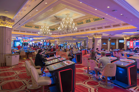 View of interior of casino in hotel with people playing slot machines. Las Vegas. USA. 03.25.2023.のeditorial素材