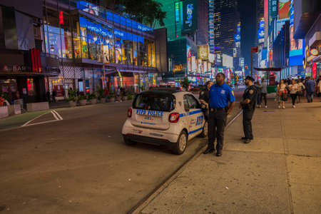 View of policemen near police car on Manhattan street at night time. New York, USA. 09.22.2022.のeditorial素材