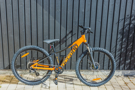 Close-up view of orange Occano mountain bike in yard of private villa. Sweden. uppsala. 04.15.2023.のeditorial素材