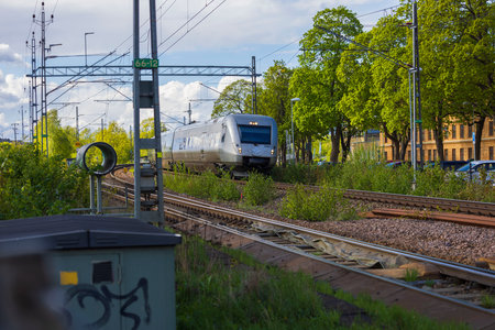 Beautiful view of coming speed electric train passing crossroad in town. uppsala. Sweden. Europe. 05.14.2022のeditorial素材