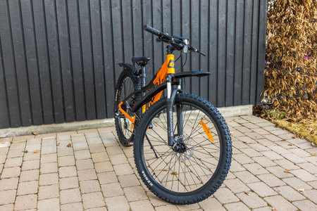 Close-up view of orange mountain bike in yard of private villa. Sweden. uppsala. 04.16.2023.のeditorial素材