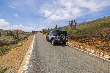 Beautiful view of off-road truck on asphalt road stone desert of natural park on island of Aruba. Aruba. Oranjestad. 05.01.2023.のeditorial素材
