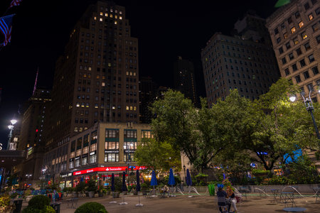 Beautiful view of night New York city landscape. Empty park square with two bystanders. New York. USA.のeditorial素材