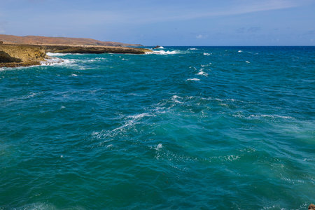 Beautiful view of rocky coast of island of Aruba against backdrop of turquoise water of Atlantic ocean.の写真素材