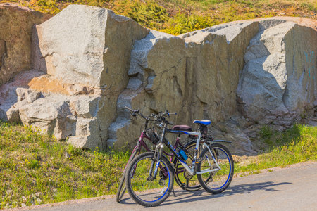 Close-up view of asphalt road with two bicycles against backdrop of mountain. Sweden.のeditorial素材