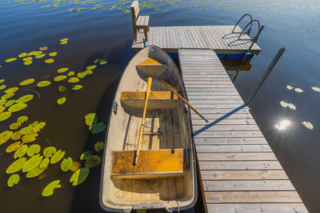 Close up view of lake with boat parked in pier on water background. Sweden.の写真素材