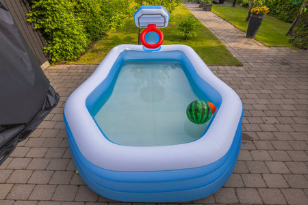 Close-up view of inflatable outdoor swimming pool filled with water in front yard.の写真素材