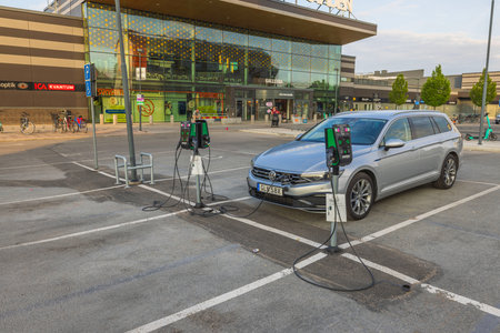 View of connected charging cable to Volkswagen car from electric vehicle charging station. Sweden.のeditorial素材