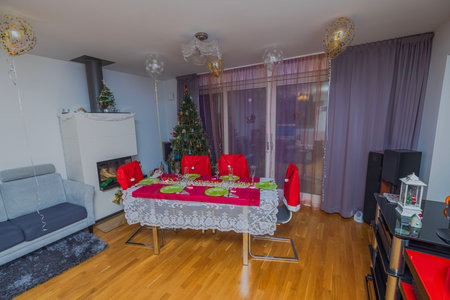 Beautiful view interior of room with Christmas tree decoration and served table.の写真素材