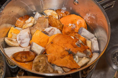 Close-up view of pot of water with peeled and chopped mushrooms in kitchen at home. Sweden.の写真素材