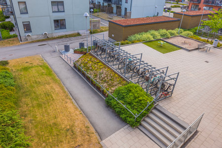 View of courtyard o modern apartment building with children's playground and bicycle parking.のeditorial素材