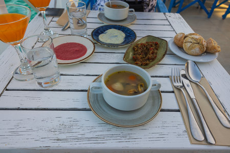 Close-up view of food plates on white wooden table. Eating out concept.の写真素材