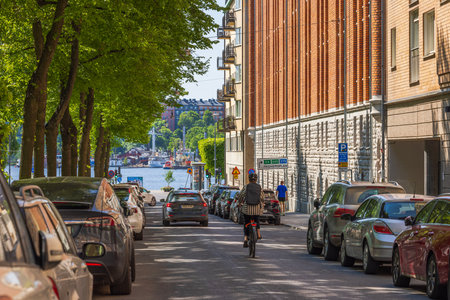Cityscape view showing cars and cyclist on road leading to embankment in center of Stockholm. Sweden.のeditorial素材