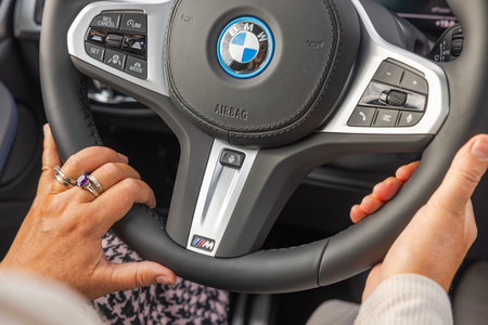 Close-up view of woman's hands on steering wheel of electric car BMW iX3 M sport.のeditorial素材