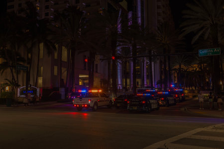 Night view of Collins Avenue with multiple police cars their flashing lights illuminating ensuring safety and order. USA. Miami Beach.のeditorial素材