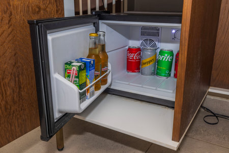 Close-up view of open minibar in hotel room, stocked with variety of alcoholic beverages, juices and sodas for guests to enjoy. Willemstad. Curacao.のeditorial素材