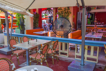 Colorful interior view of restaurant on Ocean Drive, Miami Beach, equipped with misting fan for comfort of guests. Miami Beach. USA.のeditorial素材
