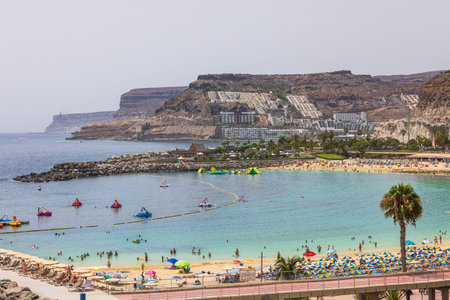 Coastal mountainous outline of Atlantic Ocean, featuring sandy beach, water attractions and hotels on picturesque island of Gran Canaria. Spain.のeditorial素材