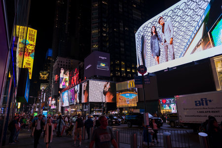 People stroll along Broadway in nighttime New York City amid  glowing LED advertising panels on skyscrapers. New York. USA.のeditorial素材