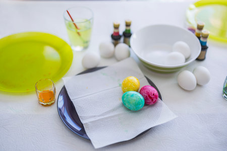 Close-up view of Easter eggs lying on the table in a plate, painted by a child.の写真素材
