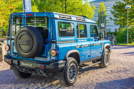Close-up view of a blue INEOS Grenadier off-road vehicle parked outdoors, showcasing its rugged...