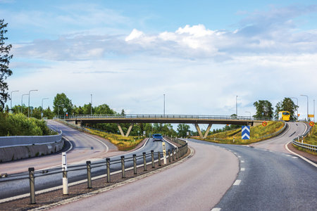 Picturesque view of highway interchange with bridge and moving vehicles, showcasing dynamic flow of...