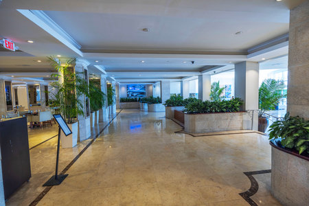 Modern hotel lobby with marble floors, indoor plants, bright lighting, and spacious, elegant design. Miami Beach. USA.のeditorial素材