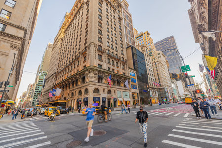 Busy crossroad with pedestrian crossings and traffic on Fifth Avenue, surrounded by skyscrapers and...