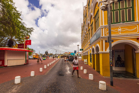 Willemstad city center on Curacao with pedestrian street between historic architecture and the Queen Emma Bridge over Sint Anna Bay. Willemstad. Curacaoのeditorial素材