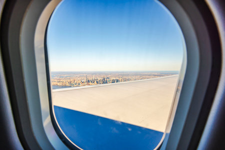 View of New York City skyline through airplane window with wing in foreground. USA.の写真素材