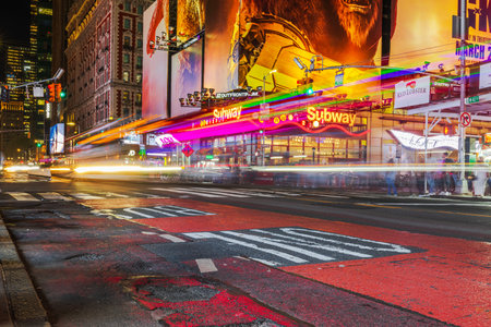 Nighttime Manhattan on Broadway with streaks of car headlights and blurred light trails against...