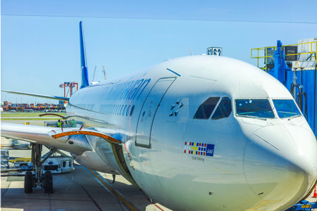 Close-up view of a large commercial airplane parked at the airport gate preparing for boarding with...