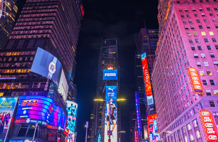Times Square at night featuring PUMA advertisements, vibrant billboards, and city lights illuminating the New York skyline. USA.のeditorial素材