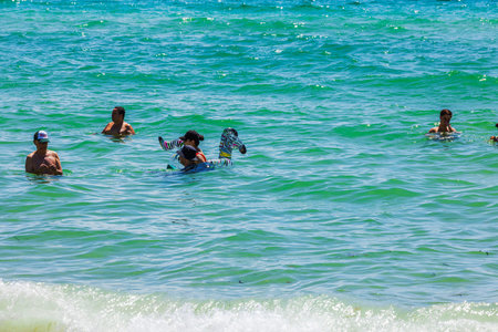 People swimming and relaxing in turquoise waters Atlantic ocean of Miami Beach on sunny day. Miami...