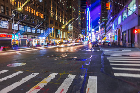 Night street view in Manhattan, New York City, featuring colorful neon lights, blurred car trails, and vibrant urban energy. New York. USA.のeditorial素材