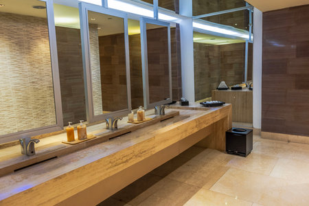 Modern restroom interior featuring sleek marble countertop with multiple sinks and mirrors. Mexico.の写真素材