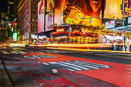 Vivid night scene of Times Square in New York City with illuminated billboards, subway sign and motion blur from passing traffic. New York. USA.のeditorial素材