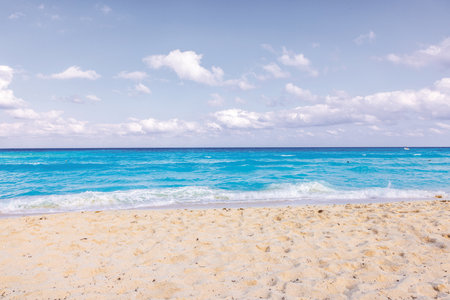 Caribbean Sea with turquoise waves and sandy beach under partly cloudy sky. Mexico.の写真素材