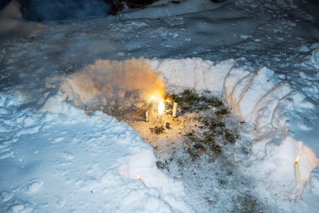 Fireworks and candles burning in snowy ground during winter night celebration.のeditorial素材