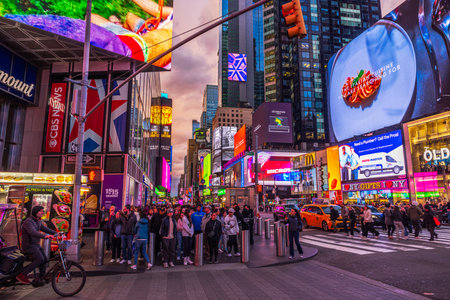 Times Square evening scene with colorful billboards, crowded crosswalk, and illuminated advertisements in New York City. New York. USA.のeditorial素材