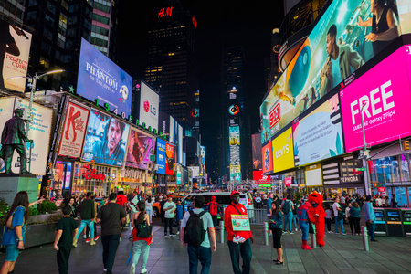 Vibrant nighttime view of Times Square filled with illuminated billboards, advertising displays, crowds and lively atmosphere. New York. USA.のeditorial素材