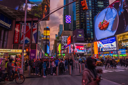 Bustling Times Square at dusk with vibrant billboards, colorful neon lights, crowded sidewalks and lively urban energy. New York. USA.のeditorial素材