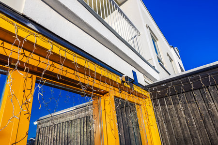 View of modern villa facade with panoramic windows, security camera, solar panel and festive Christmas garlands.の写真素材