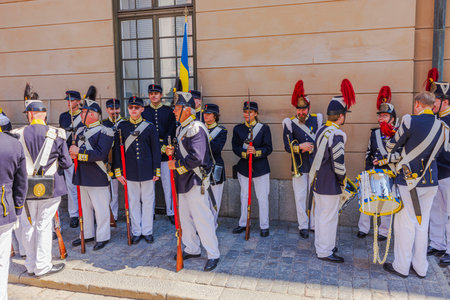 Historical reenactment group in traditional Swedish military uniforms standing near Royal Palace during Sweden National Day. Sweden. Stockholm.のeditorial素材