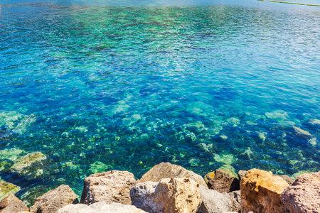 Clear turquoise water of Atlantic Ocean with submerged rocks near rocky shore on Gran Canaria. Spain.の写真素材