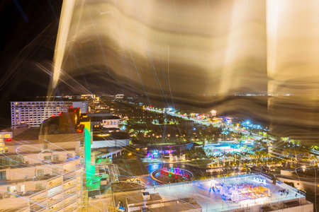 Blurred night cityscape with neon lights and motion trails over a resort area near the Caribbean Sea. Cancun. Mexico.の写真素材